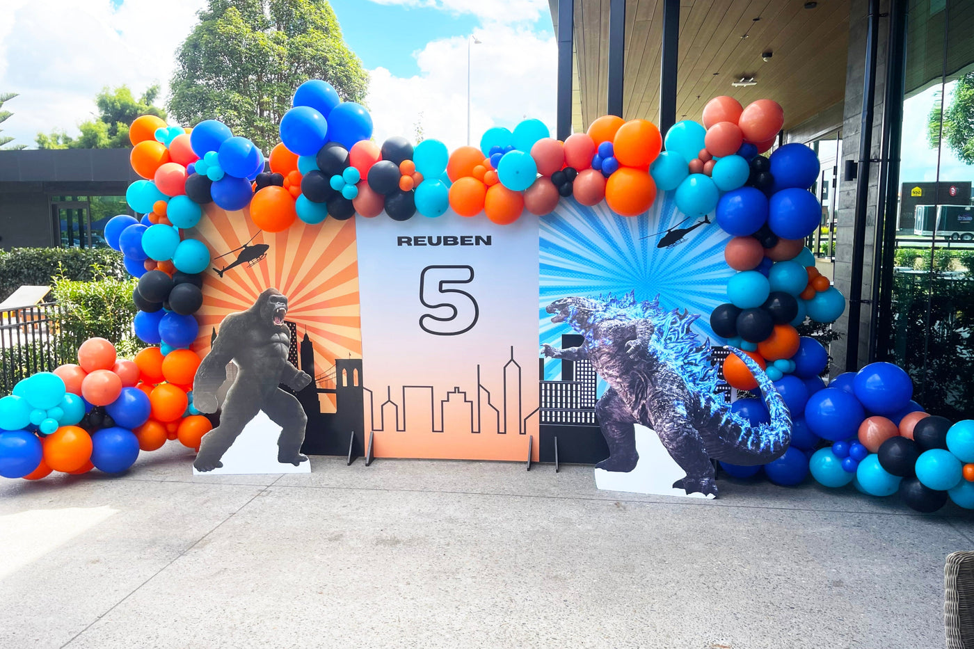 Auckland Bespoke Party Planners. Bespoke Balloon Arch arch with Godzilla cardboard cutouts of characters, featuring a birthday banner with the number 5. 